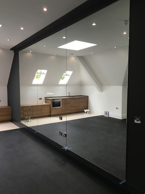 Frameless glass partition in loft conversion by Putney glaziers