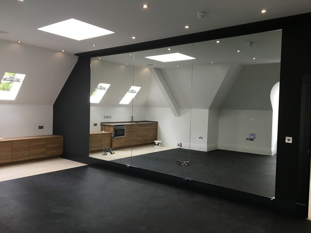 Frameless glass wall dividing loft conversion in Putney